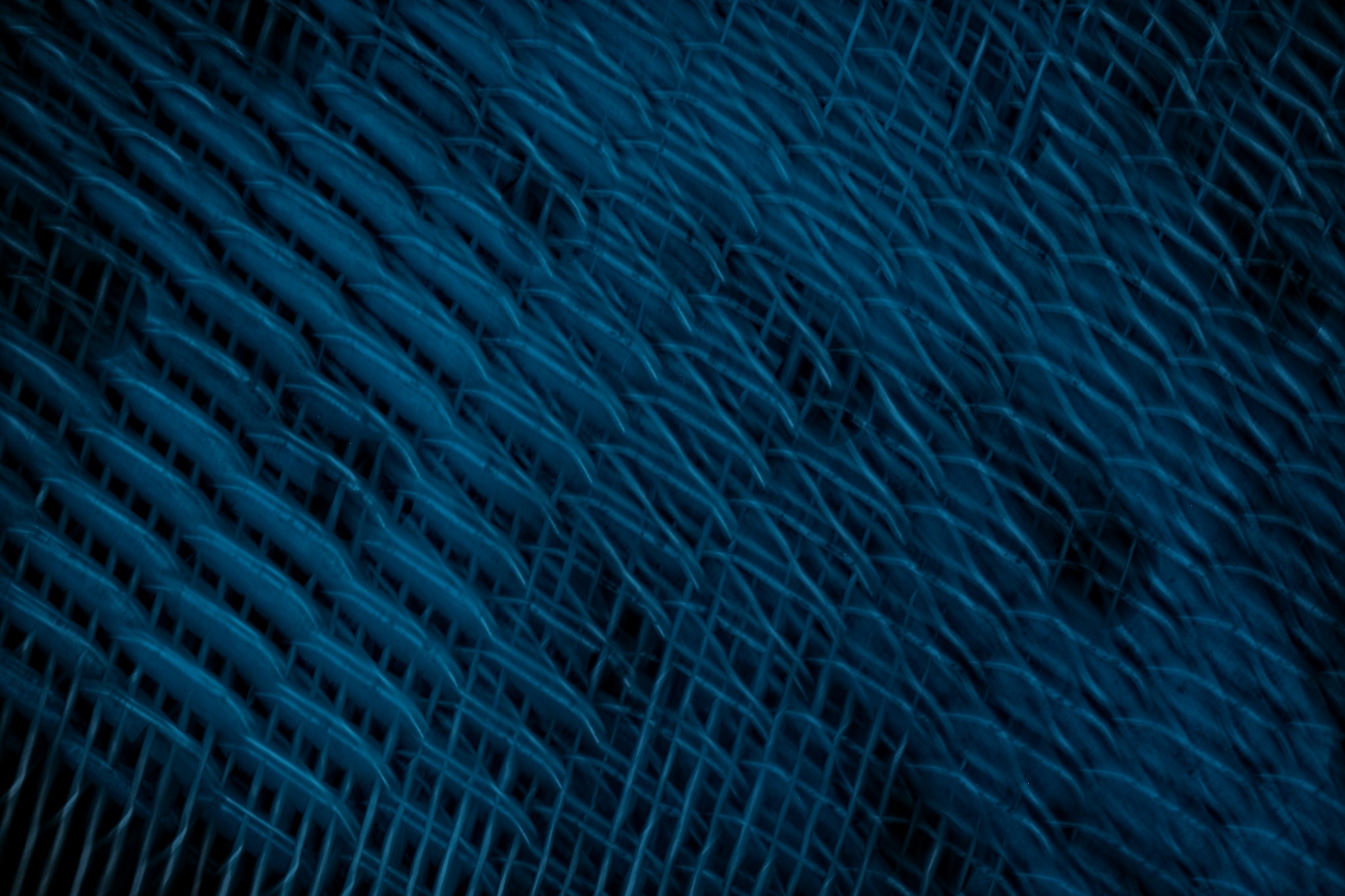 Real camera-motion photograph of interlaced blue strands, illustrating cooperation and connected work